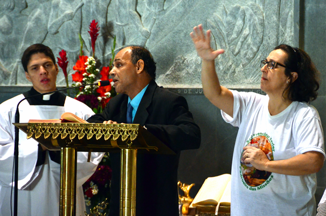 Jorge, membro da Pastoral do Cego na Missa da Peregrinação do Ano da Misericórdia em junho de 2016. Ao lado a intérprete de Libras , Laura. Jorge faz a leitura em braile.