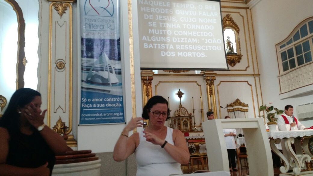 Kátia, membro da Pastoral faz a tradução da Oração da Profissão de Fé, ao lado da intérprete Marilene da mesma Igreja. 