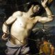 Imagem de Sebastião, sem camisa, com duas flechas no corpo. ao lado tem um soldado romano.