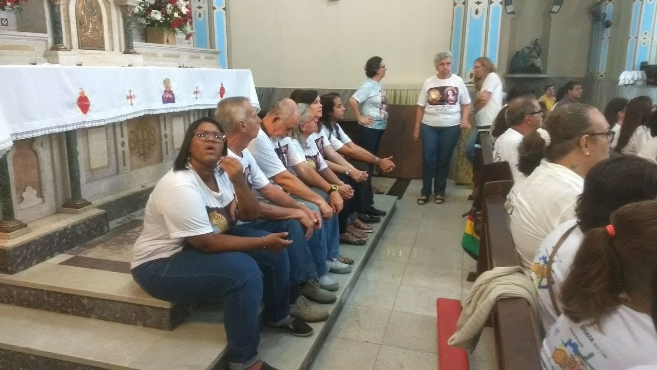 Grupo de Jovens da Pastoral participa da Missa no Méier. Estão sentados na escada de um altar lateral, mas se tem a visão do altar mor. 
